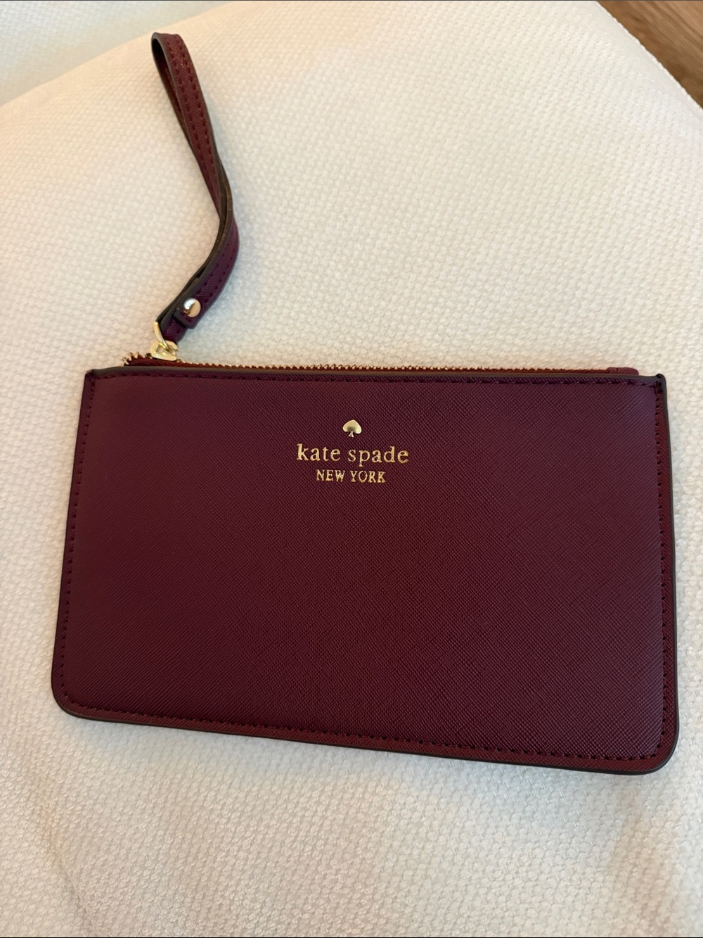 kate spade burgundy wristlet clutch with gold logo